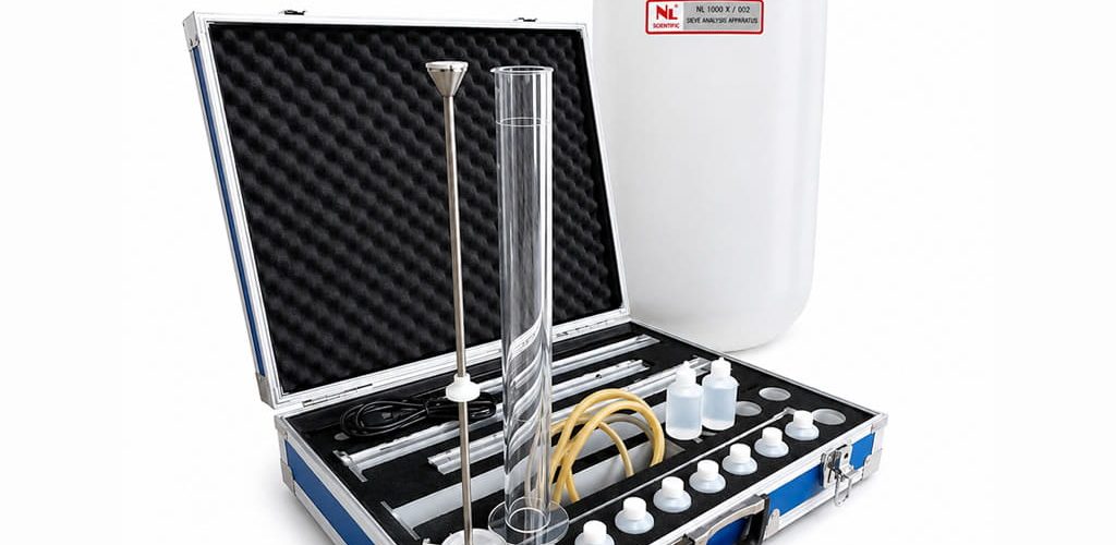 Set lengkap alat uji Sand Equivalent Shaker NL 1001 portabel di dalam koper aluminium biru, dilengkapi tabung silinder ukur, batang penumbuk, dan jerigen larutan.